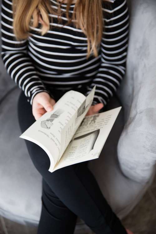 Young Girl Flipping Pages Of A Book Photo