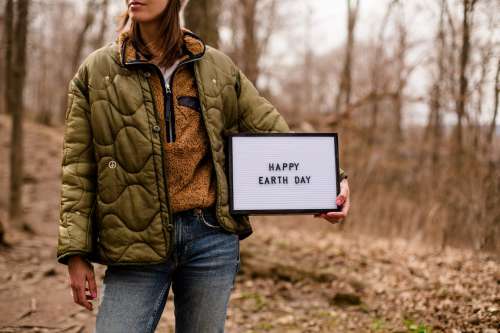 Hiker Holds Up A Sign For Earth Day Photo