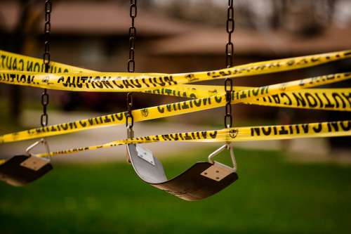 Caution Tape Wrapped Around Empty Swings Photo