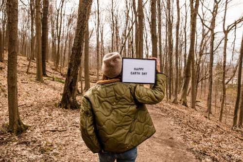 Person Holding Up A Sign In The Forest For Earth Day Photo