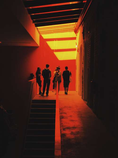 A Group Of People Stand Surrounded By A Red Glow Photo