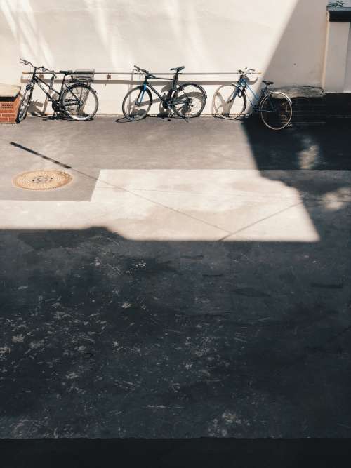 Three Bikes Leaning On A Wall Photo