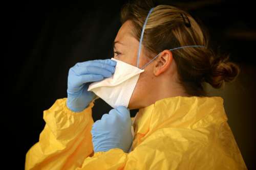 Woman in Mask, Gloves, and Gown - PPE