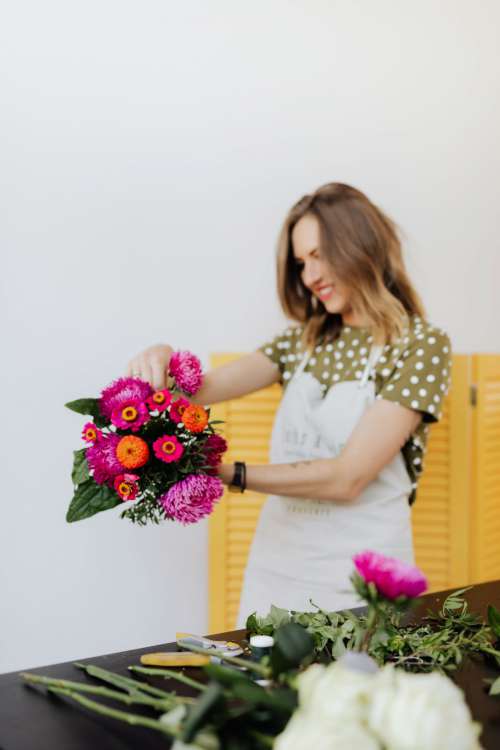 A beautiful woman florist makes a bouquet