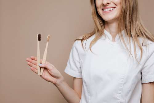 Female dentist doctor holding a bamboo toothbrushes