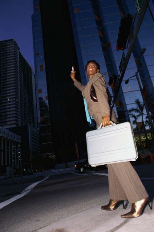 Low angle view of a businesswoman holding a briefcase hailing a taxi
