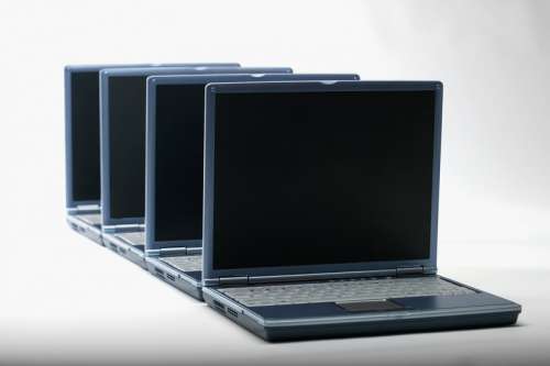 Row of four open laptop computers