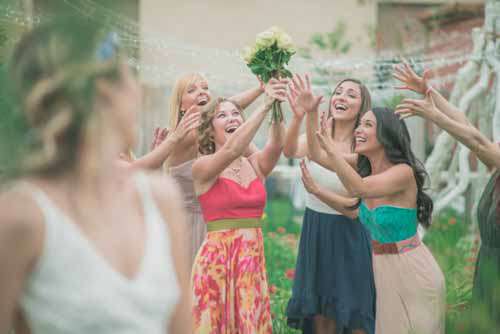 Happy Girls Catching Brides Bouquet At Outdoor Wedding