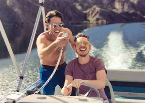Two Men Driving A Spead Boat Laughing And Having Fun