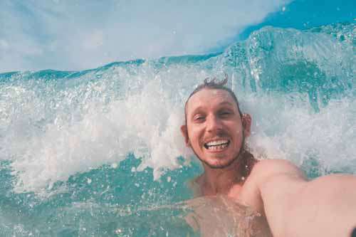 Surf Man Getting Hit By Wave Whilst Taking A Selfie
