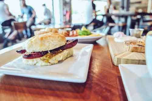 Sausage Brunch Sandwich On Table  In A Cafe
