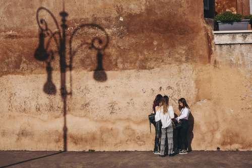 Three Women By A Rustic Wall Photo