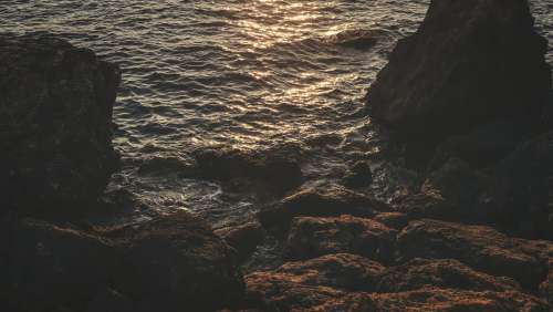 Rocky Shoreline Lit By Orange Sunset Photo