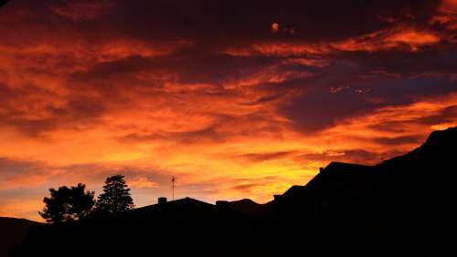 Vibrant Red Sunset Over Rooftop Photo