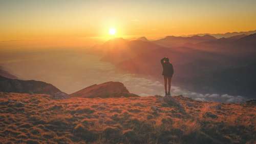 Person Watching Sunset Above The Clouds Photo