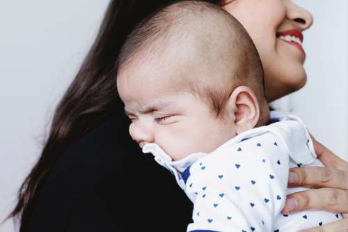 Baby Rests On Mothers Shoulder Photo