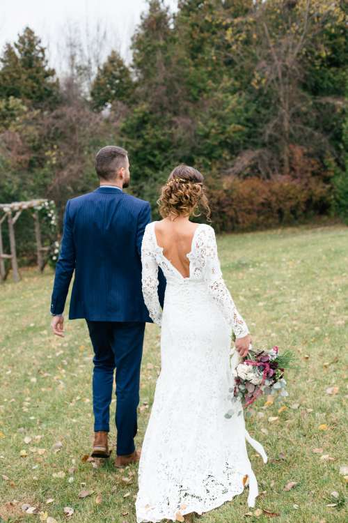 Bride And Groom Walking On The Grass Photo
