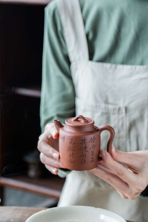 Two Hands Holding Chinese Teapot Photo