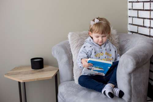 Little Girl In Her Reading Chair Photo