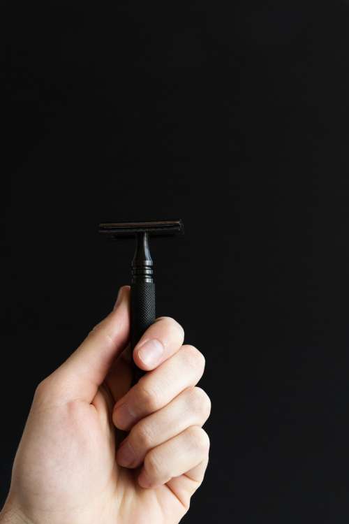 Hand Holding Black Razor Photo