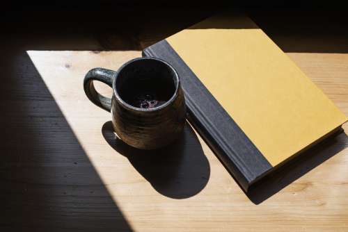 Close Up Of A Mug And A Book In Light Photo