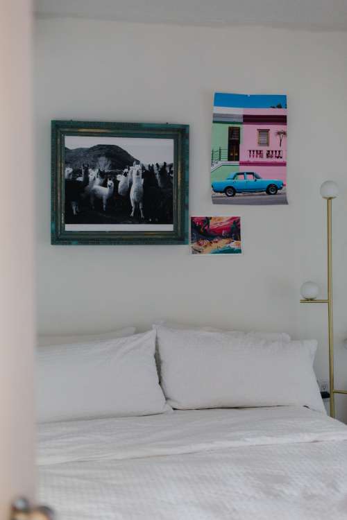 White Bed With Ecclectic Art On The Wall Photo