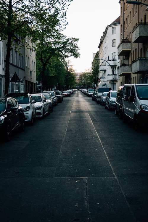 Empty Street At Sunset Full Of Parked Cars Photo