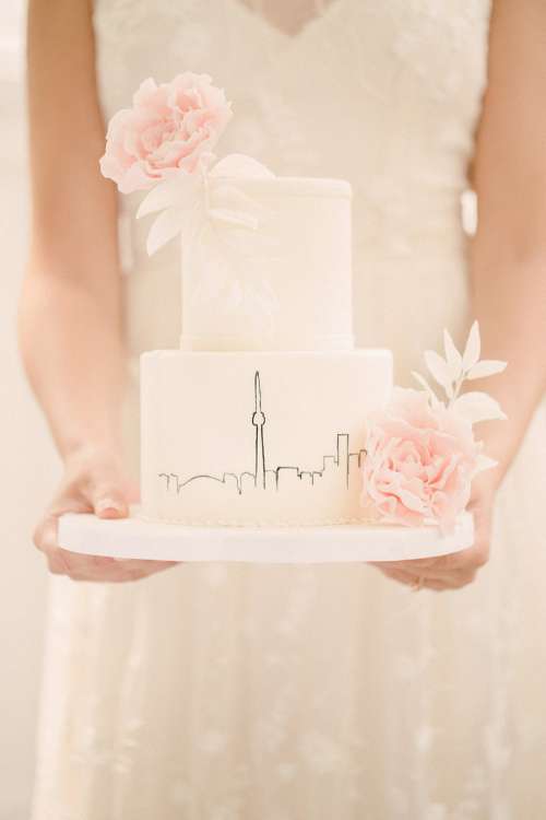 Bride Holding Out White Wedding Cake Photo