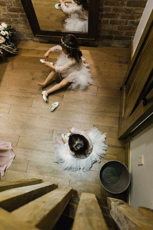 Two Children In Wedding Attire Putting On Shoes Photo