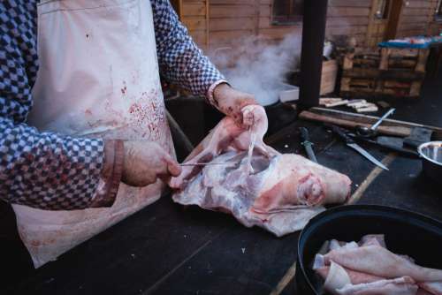 Butcher cutting pork meat