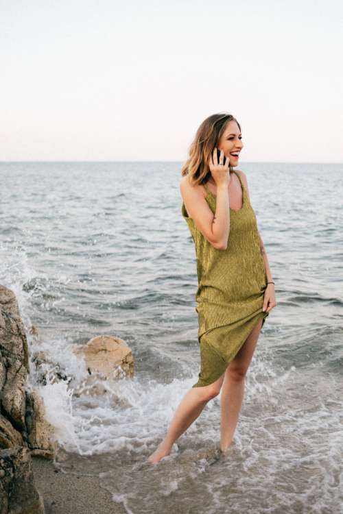 A beautiful woman on the beach is talking on the phone