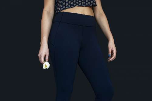 Woman In Yoga Pants Holding A Single Flower Photo