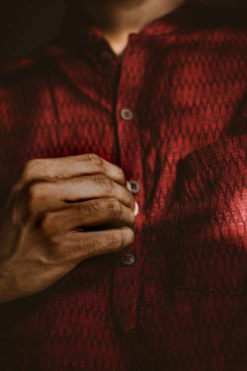 Man Buttoning A Dark Red Shirt Photo