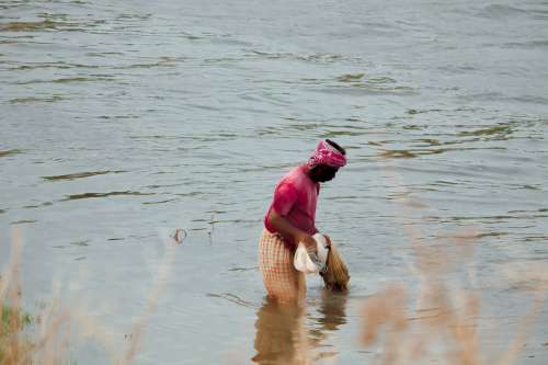 Man Wading Through Water With Fishing Net In India Photo