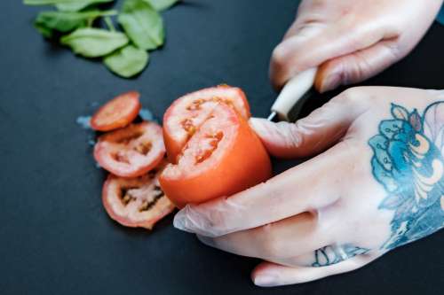 Tattooed Hands Preparing Food With Gloves Photo