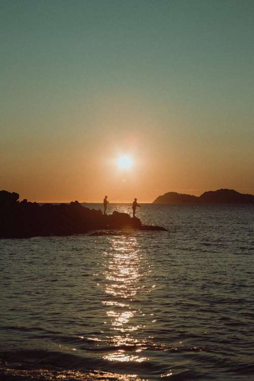 Sun Sets Behind Fishermen Photo