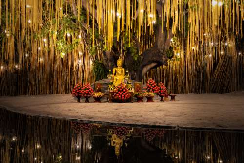 Buddhist Statues Surrounded By Flowers Photo