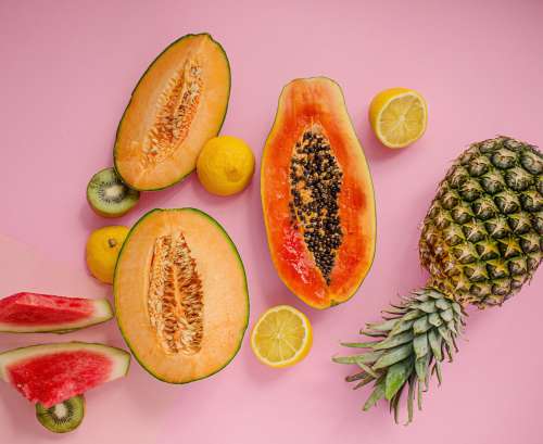 Several Different Fruits Lay On A Pink Background Photo