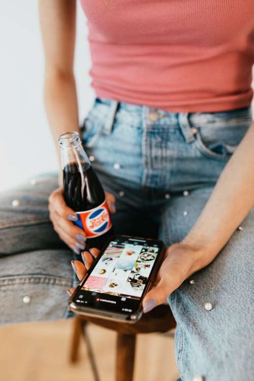 Young woman with laptop & mobile phone at home