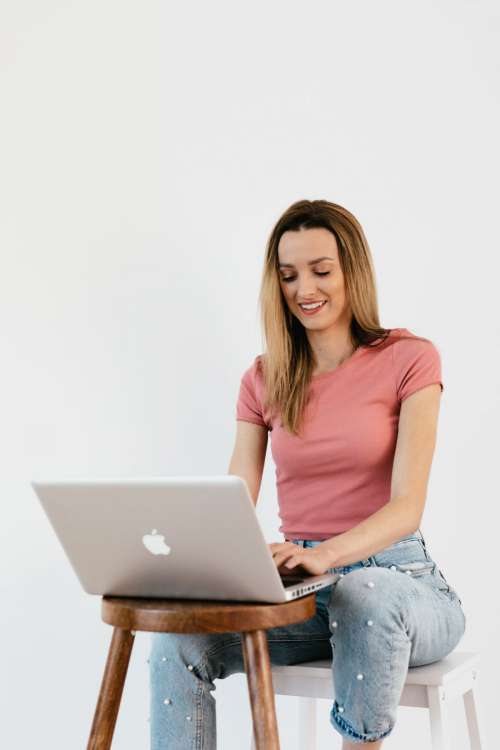 Young woman with laptop & mobile phone at home