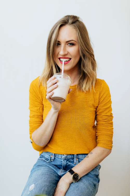 A joyful young woman drinks a McDonald's milkshake