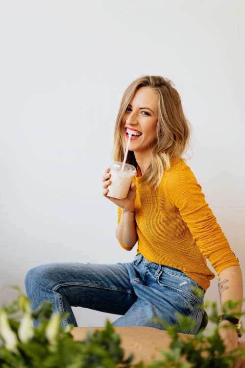 A joyful young woman drinks a McDonald's milkshake