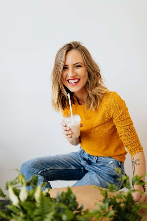 A joyful young woman drinks a McDonald's milkshake