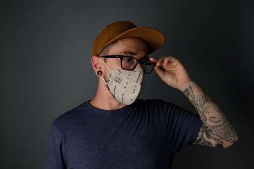 Man Adjusting His Glasses While Wearing Mask Photo