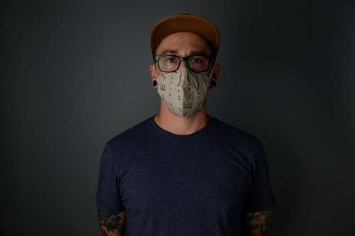 A Man Stands Wearing A Face Mask Photo