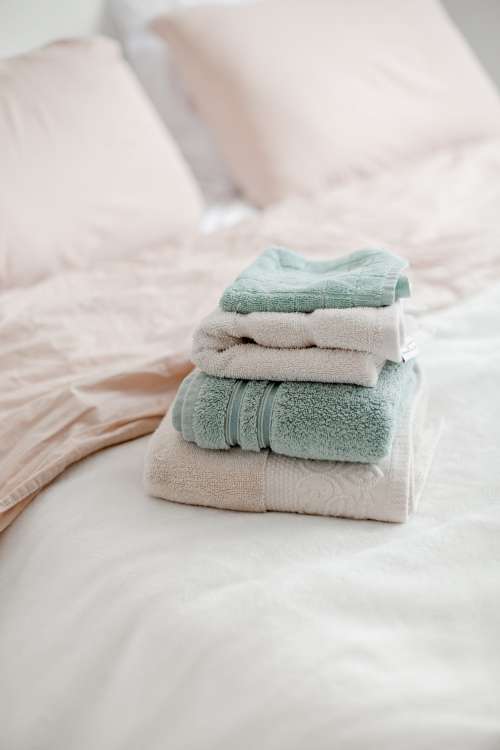Neatly Folded Towels Placed On A Bed Photo