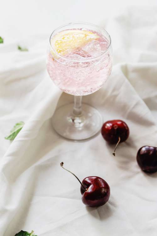 Sparkling Drink And Cherries On Fabric Photo