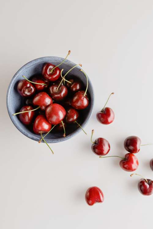 Bowl Of Red Cherries On A White Background Photo