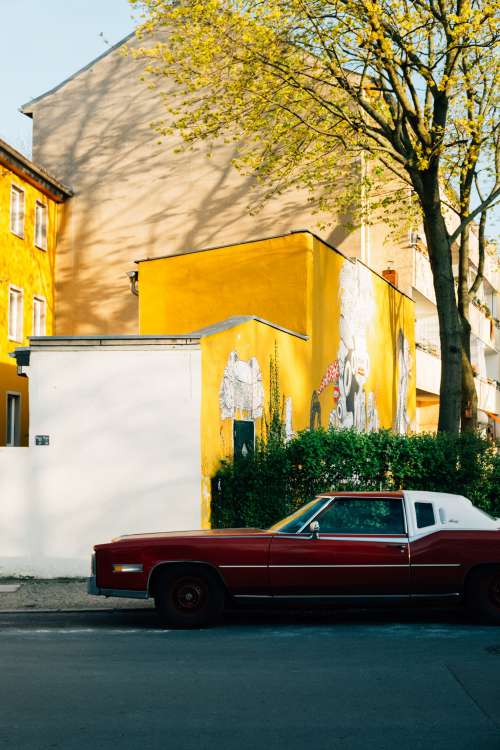 Red Classic Car In Front Of Yellow Building Photo
