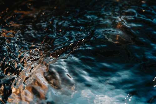 Close Up Of Flowing Water Glistening Under The Sun Photo